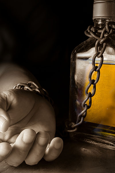 hand chained to alcohol bottle