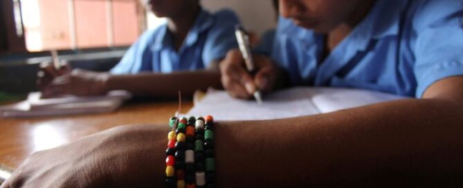 two boys siting at desks in classroom