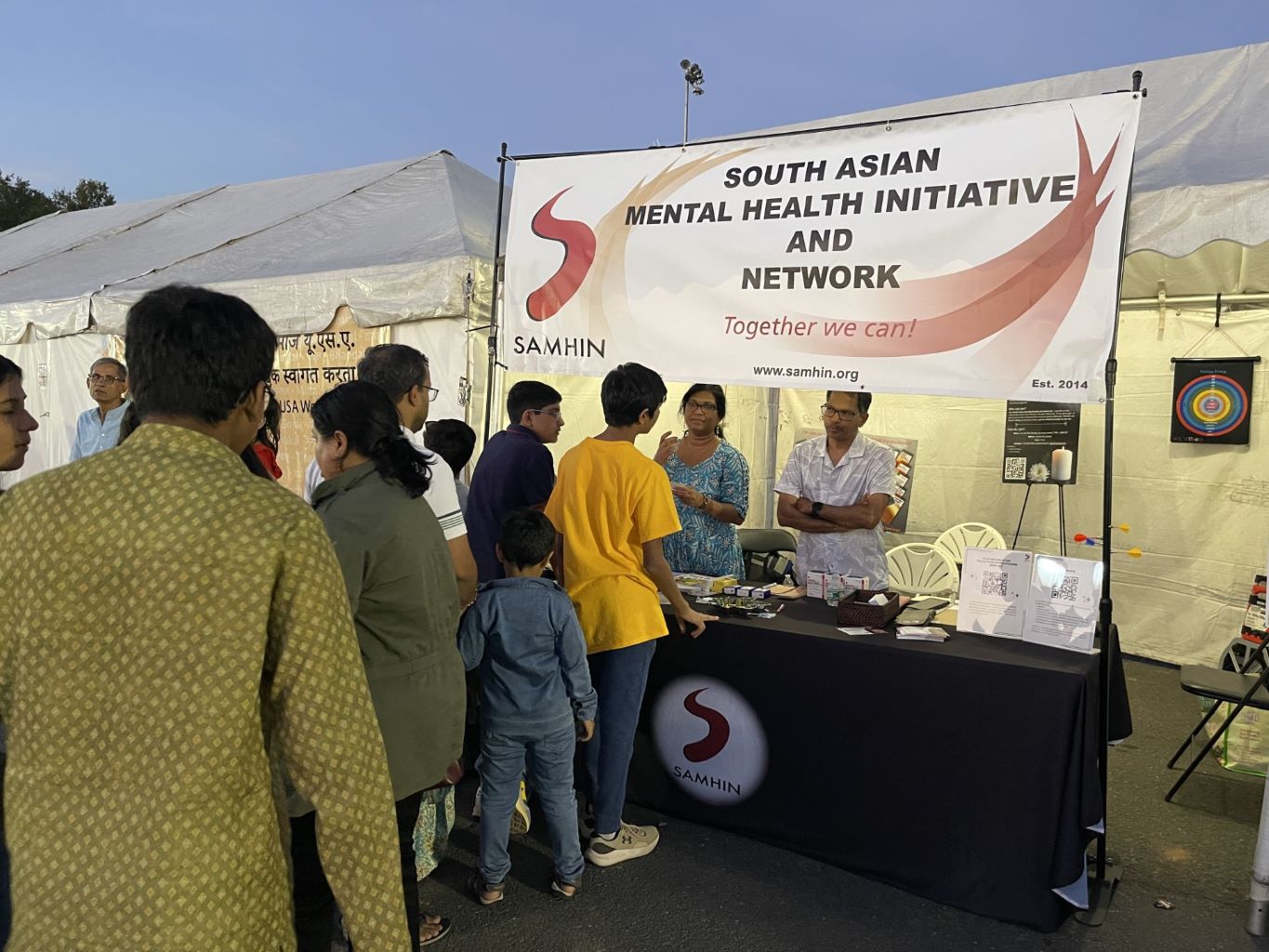 people visiting SAMHIN booth at community event