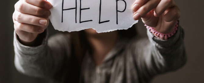 woman holding help sign