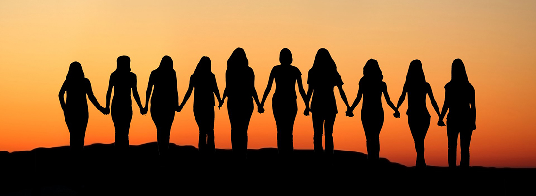 women holding hands at sunset